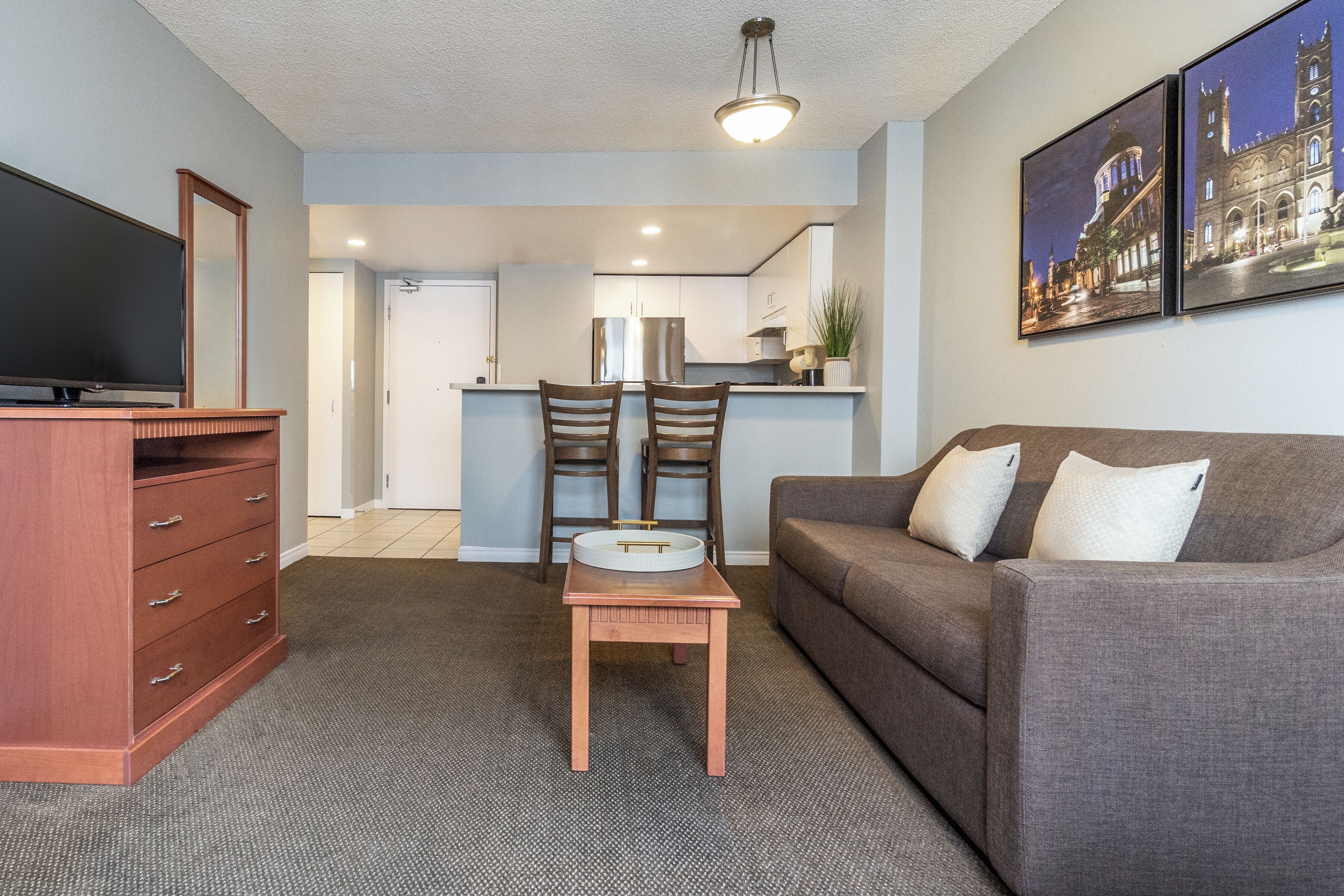 A living room with a sofa, a coffee table, a TV, and a wooden cabinet.