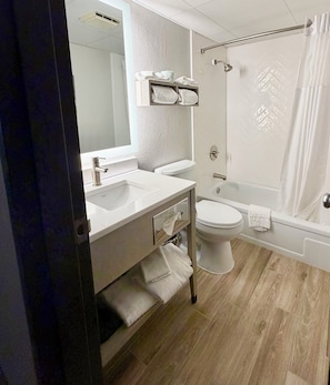 A modern bathroom with a sink, toilet, and bathtub.