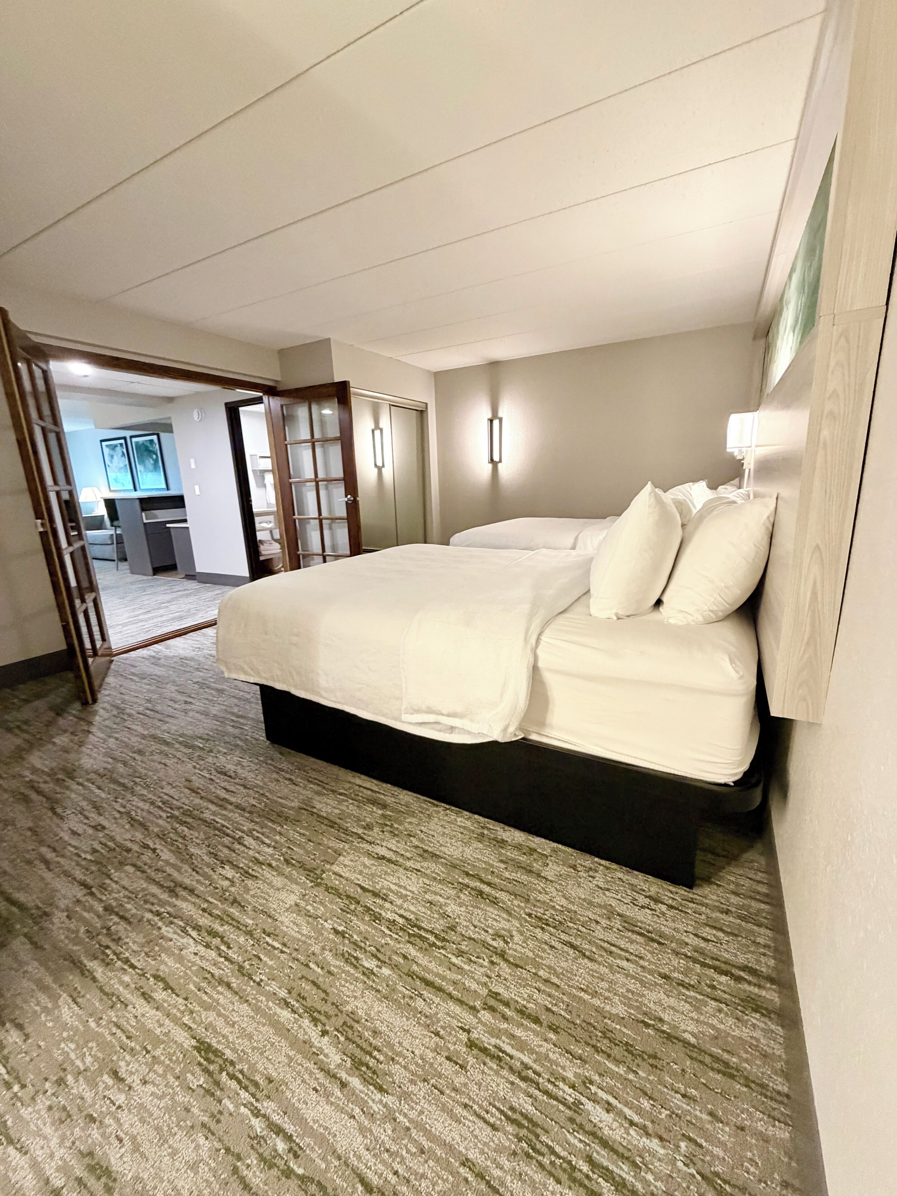 A hotel room with a large bed, a desk, and a chair.