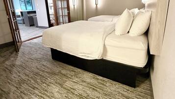 A hotel room with a large bed, a desk, and a chair.