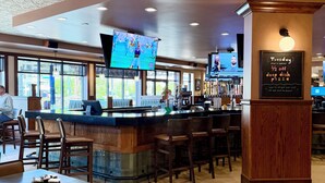 A restaurant with a bar area, multiple TVs, and a chalkboard sign advertising a special offer. - Best Western Plus Kelly Inn (St Cloud)