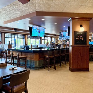A restaurant with a bar area, multiple TVs, and a chalkboard sign advertising a special offer. - Best Western Plus Kelly Inn (St Cloud)