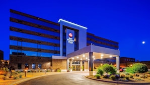 A Best Western Plus hotel with a modern design, featuring a prominent sign, a covered entrance, and landscaped outdoor area.