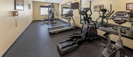 A gym with treadmills, elliptical machines, and weight equipment.