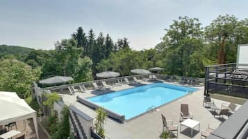 Una piscina al aire libre de temporada, sillones reclinables de piscina