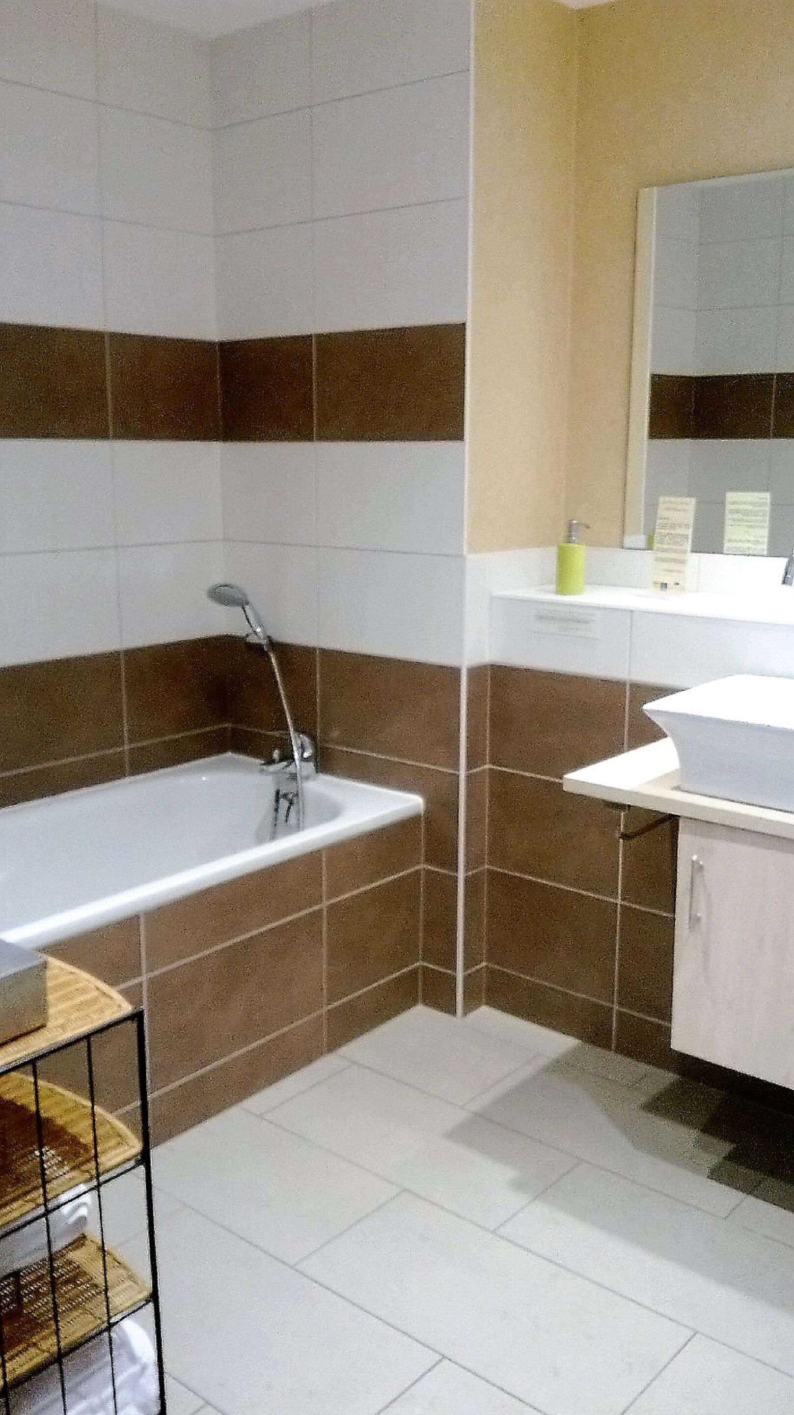 Une salle de bain avec une baignoire, un lavabo et un miroir.