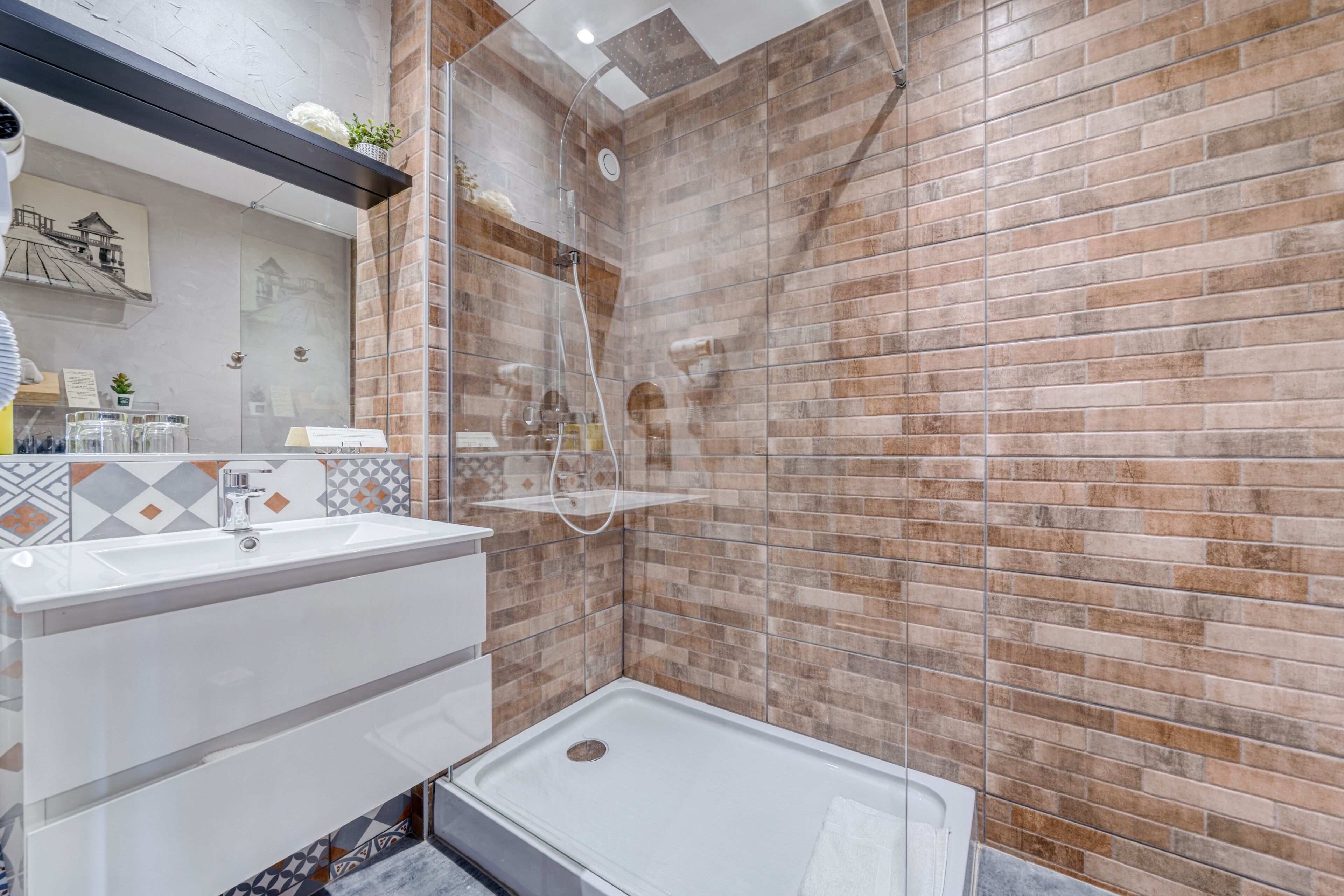 A bathroom with a shower, a sink, and a mirror.