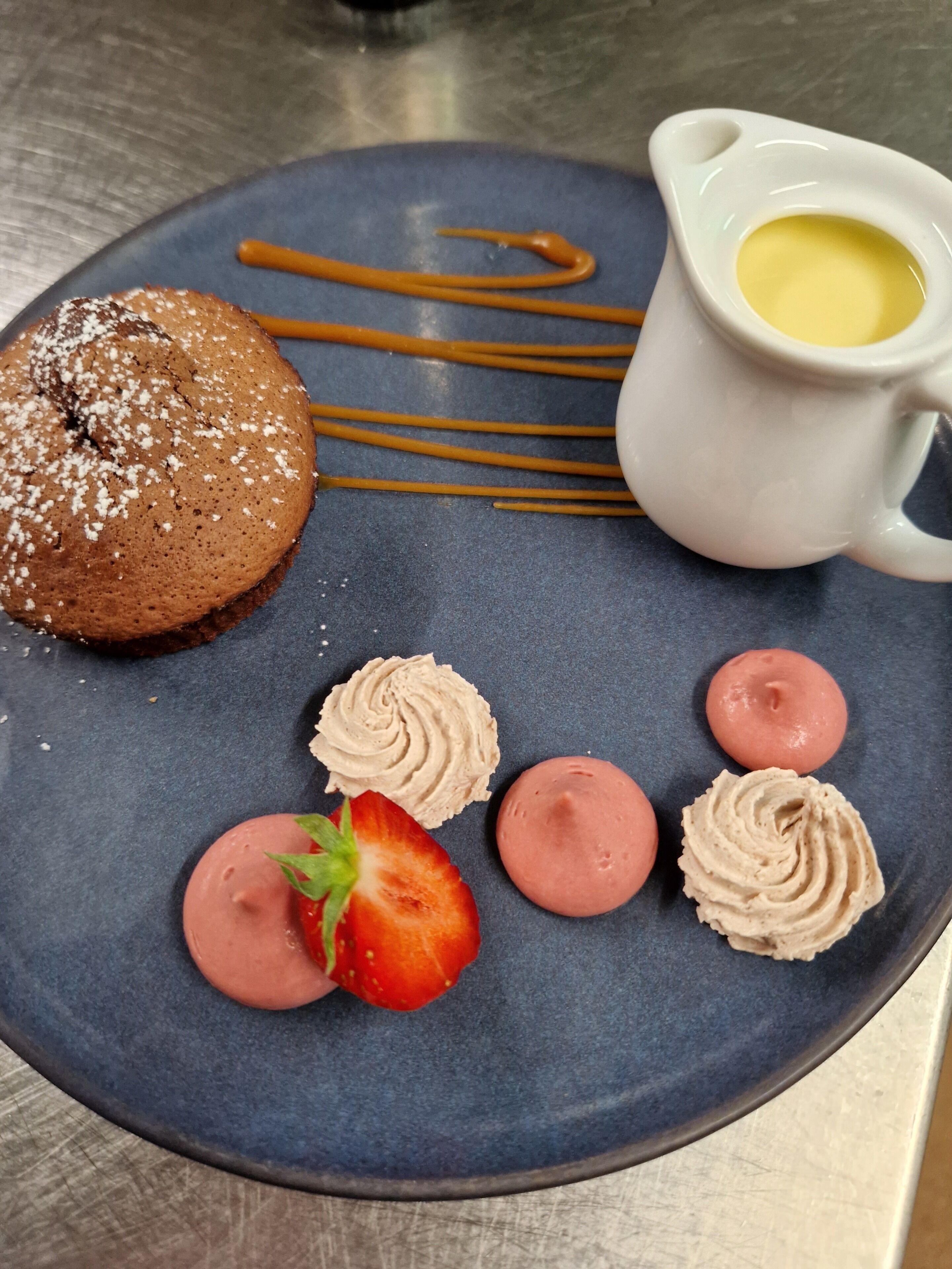 Une assiette de dessert avec un gâteau au chocolat, de la crème fouettée et des fraises.