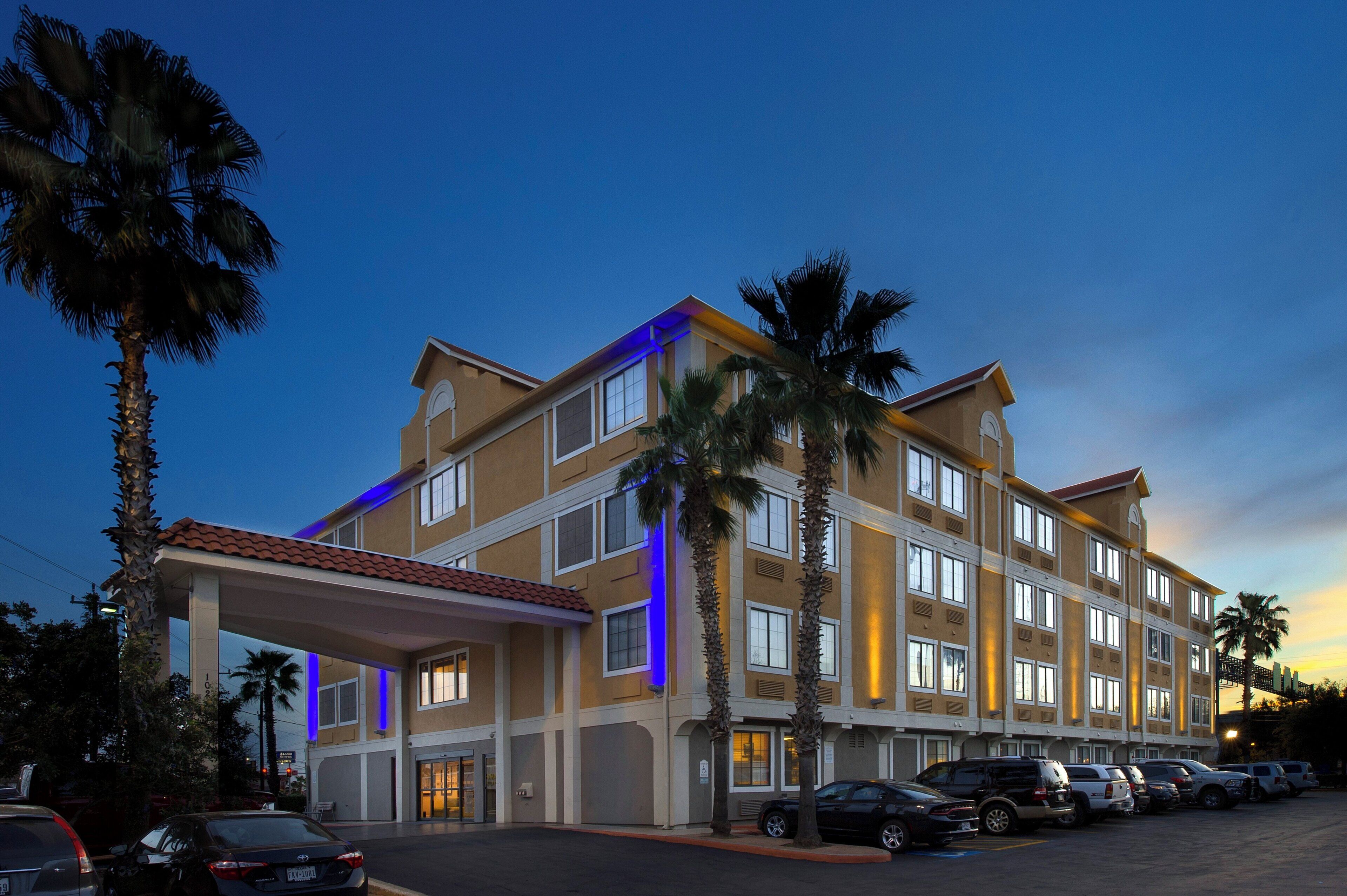 A multi-story hotel with a covered entrance and a parking lot.