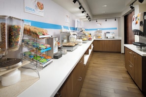 Zona de buffet per a esmorzars amb diverses opcions d'alimentació, com cereals, avena i aigua calenta.