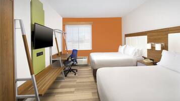 A hotel room with two beds, a desk with a chair, a television, and a window.