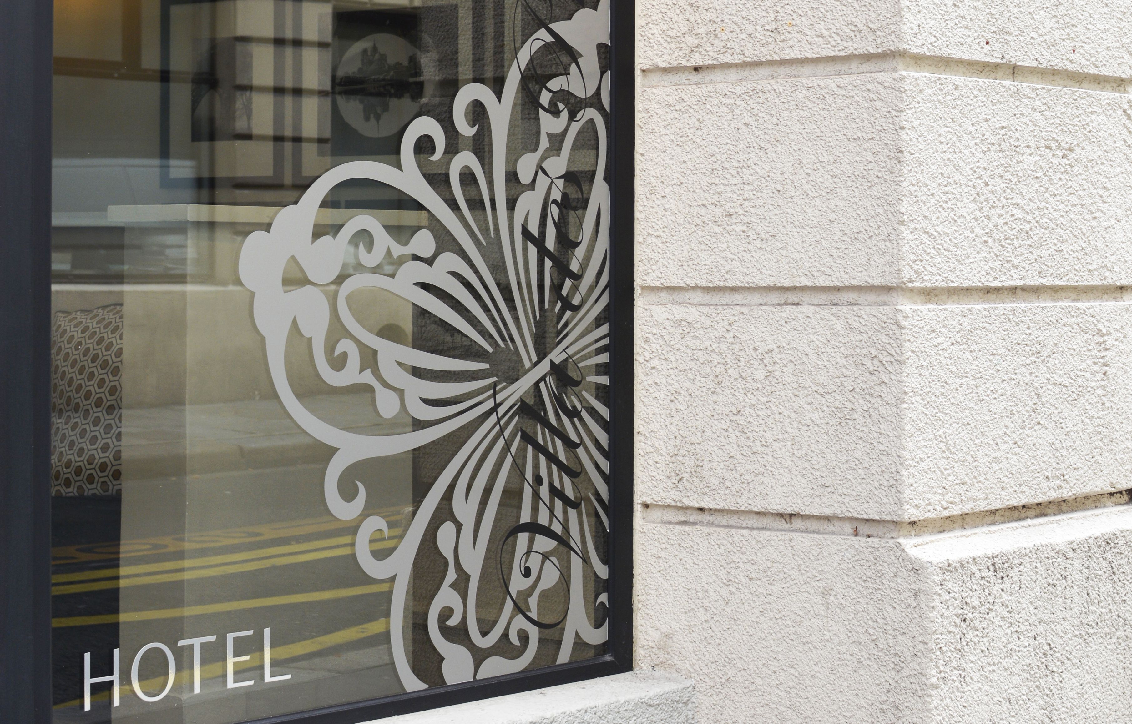 L’entrée d’un hôtel, agrémentée d’un portail en métal décoratif orné de motifs de papillons.