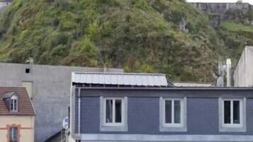 A hotel named "HOTEL ST ETIENNE" with a view of a castle on a hill in the background.
