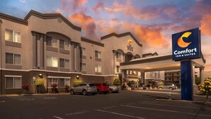 A Comfort Inn & Suites hotel with a parking lot, a clear sky, and a signboard. - Comfort Inn & Suites Sacramento - University Area (Sacramento)