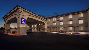 Um hotel com entrada coberta, várias varandas e uma bandeira.