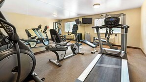 Ein Fitnessstudio mit verschiedenen Trainingsgeräten, darunter Laufbänder, Ergometer und Kraftgeräte.