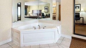 Ein modernes Badezimmer mit einer großzügigen, freistehenden Badewanne, einem Doppelwaschbecken und einem großen Spiegel.