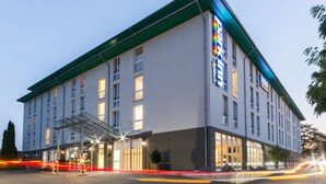 Un hotel moderno con techo plano, ventanas amplias y una entrada destacada con galería techada.