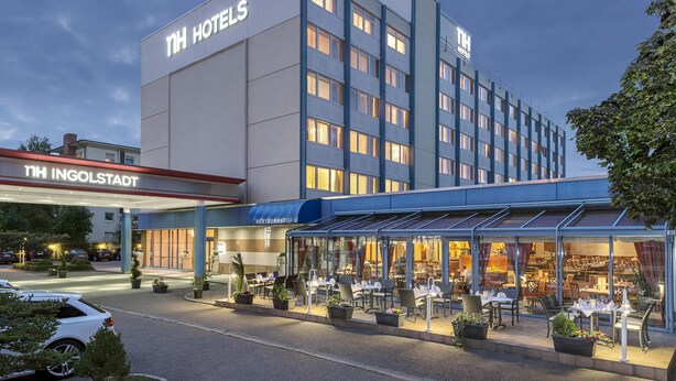 A hotel with a modern design, a restaurant, and outdoor seating. - NH Ingolstadt (Ingolstadt)