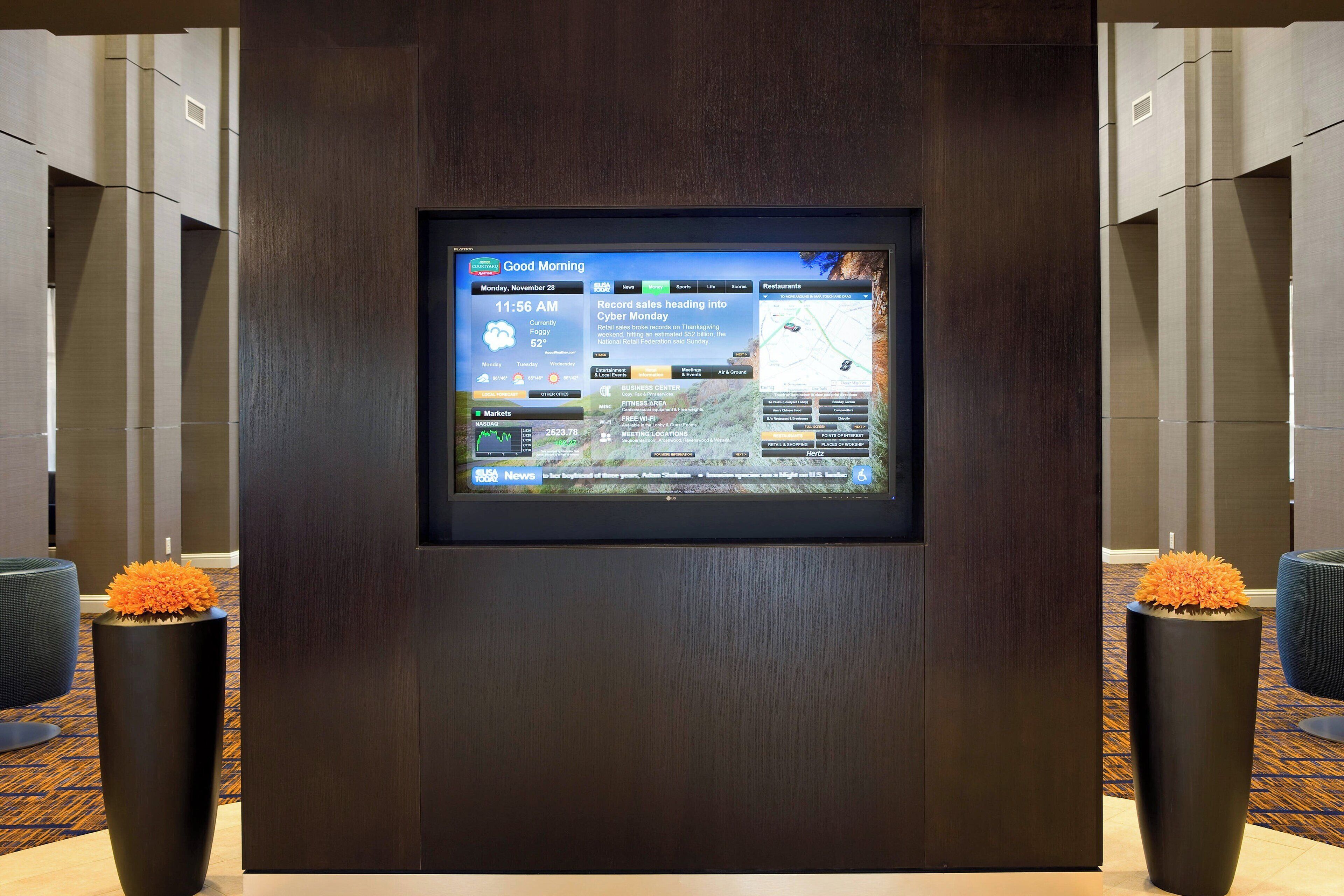 Ein digitales Display in einer Lobby mit einem Nachrichtenfeed und einer Karte.