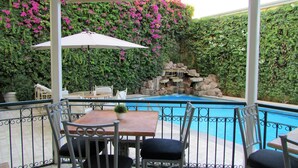 A covered outdoor area with a pool, seating, and a waterfall feature. - Best Western Hotel Posada Del Rio Express (Torreón)