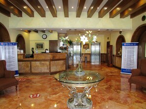Welcome to our lobby, featuring a spacious area with a comfortable seating area, reception desk, and helpful information sign.