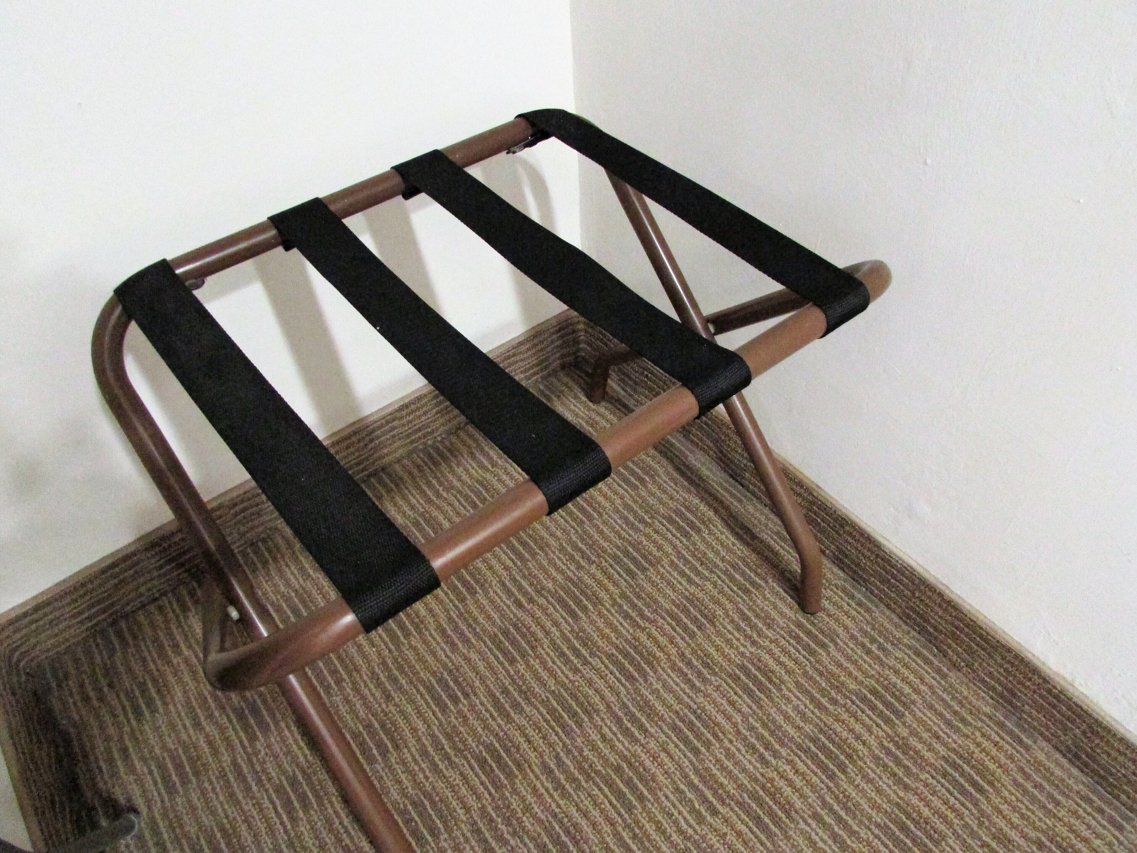 A metal stool with black straps.