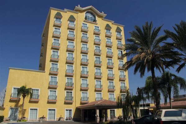 Stunning hotel building with a symmetrical design, featuring balconies and a covered entrance.