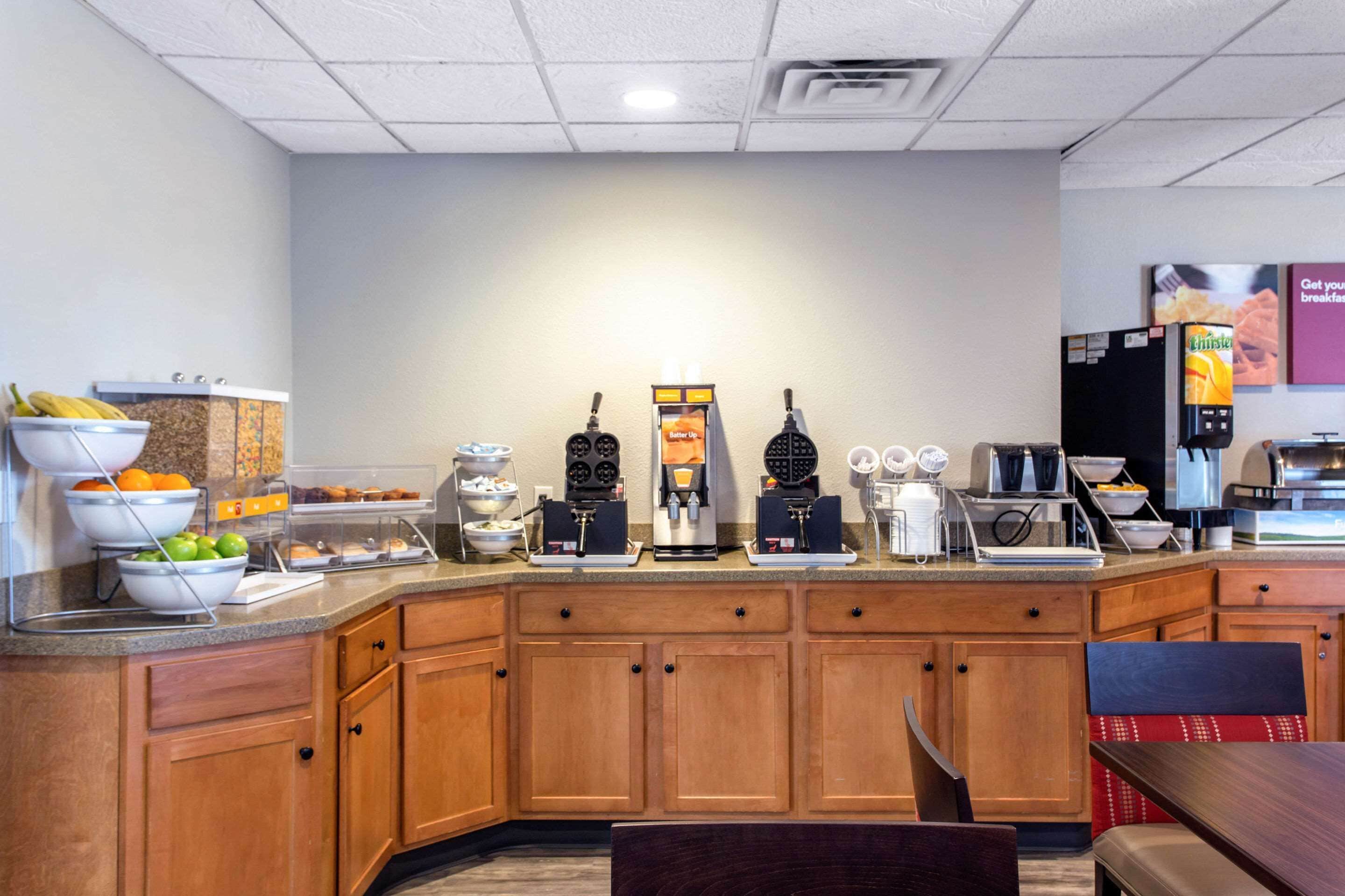 A breakfast bar with various food items and coffee machines.
