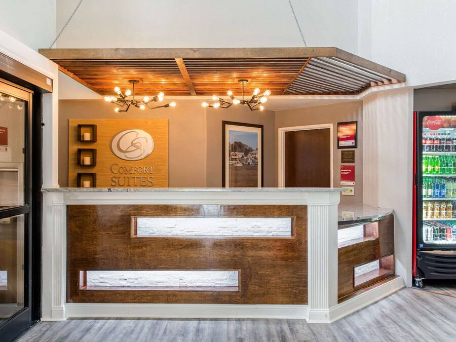 A reception desk with a wooden finish and a sign reading "Coconuts Suites".