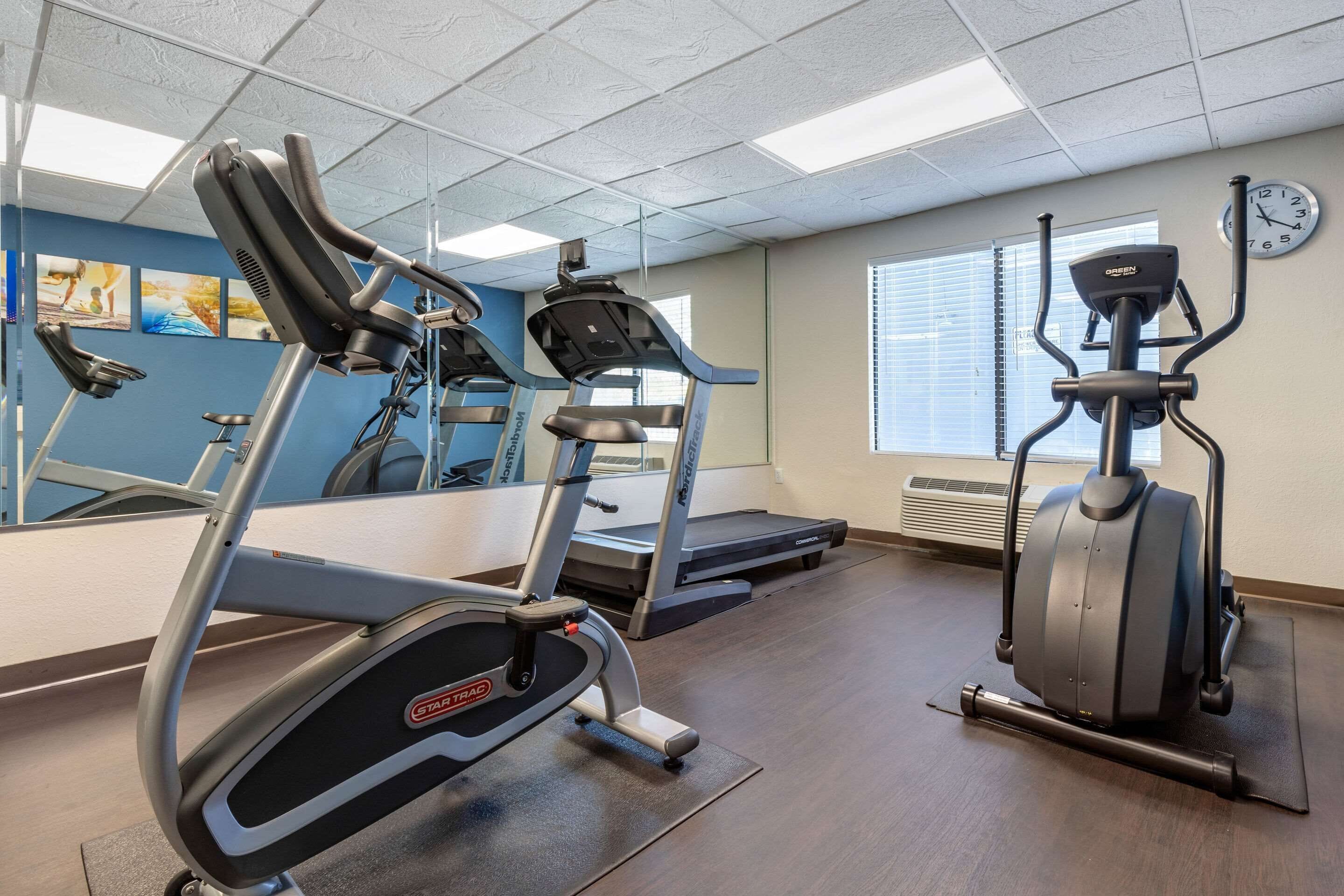 A gym with treadmills, an elliptical, and a stationary bike.