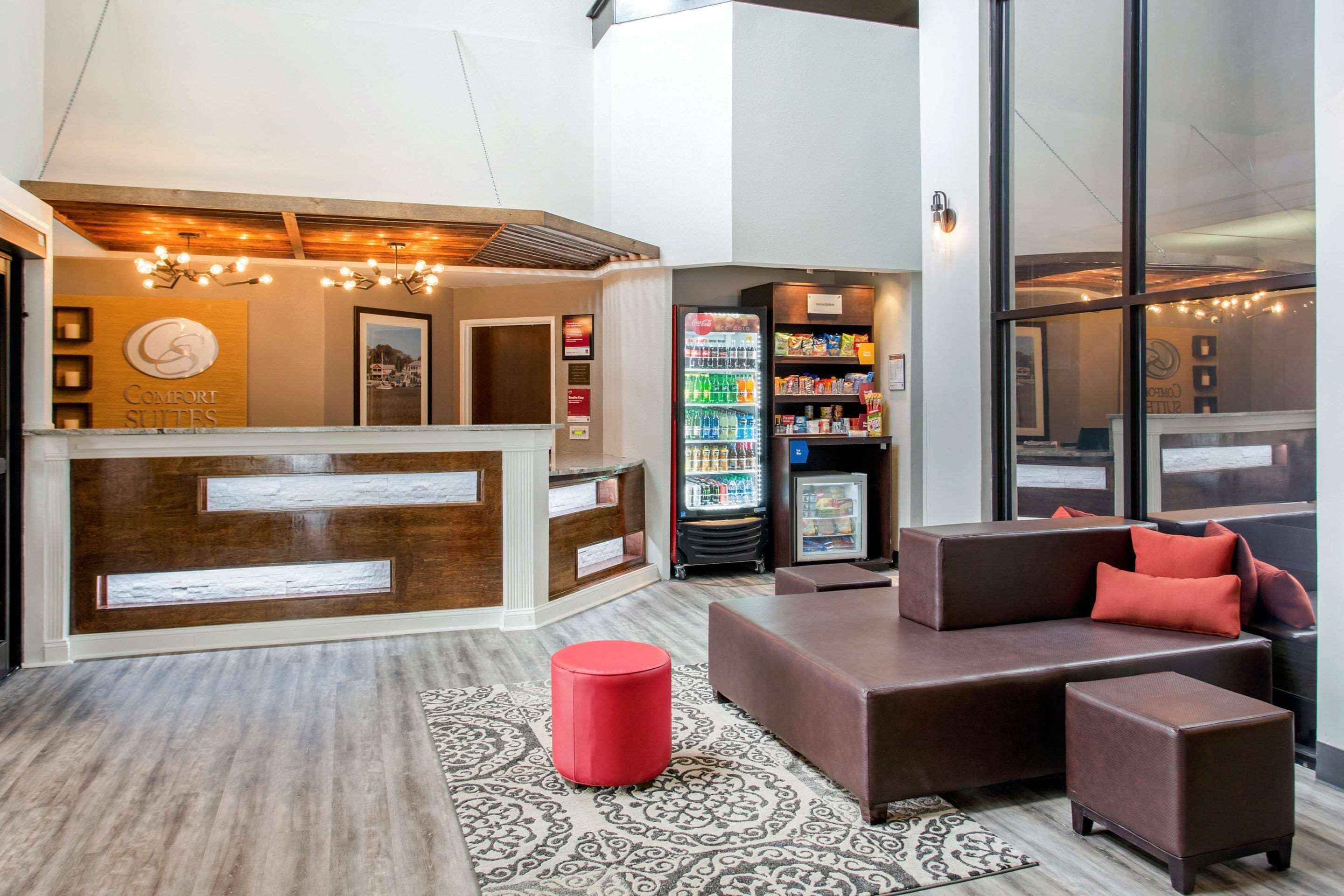 A hotel lobby with a reception desk, seating area, and vending machines.