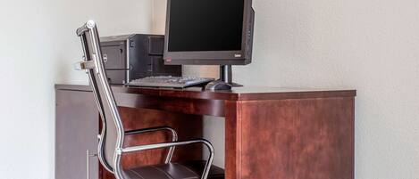 Un escritorio moderno con una computadora, teclado y una silla.