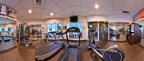 A gym with treadmills, elliptical machines, and weight equipment.