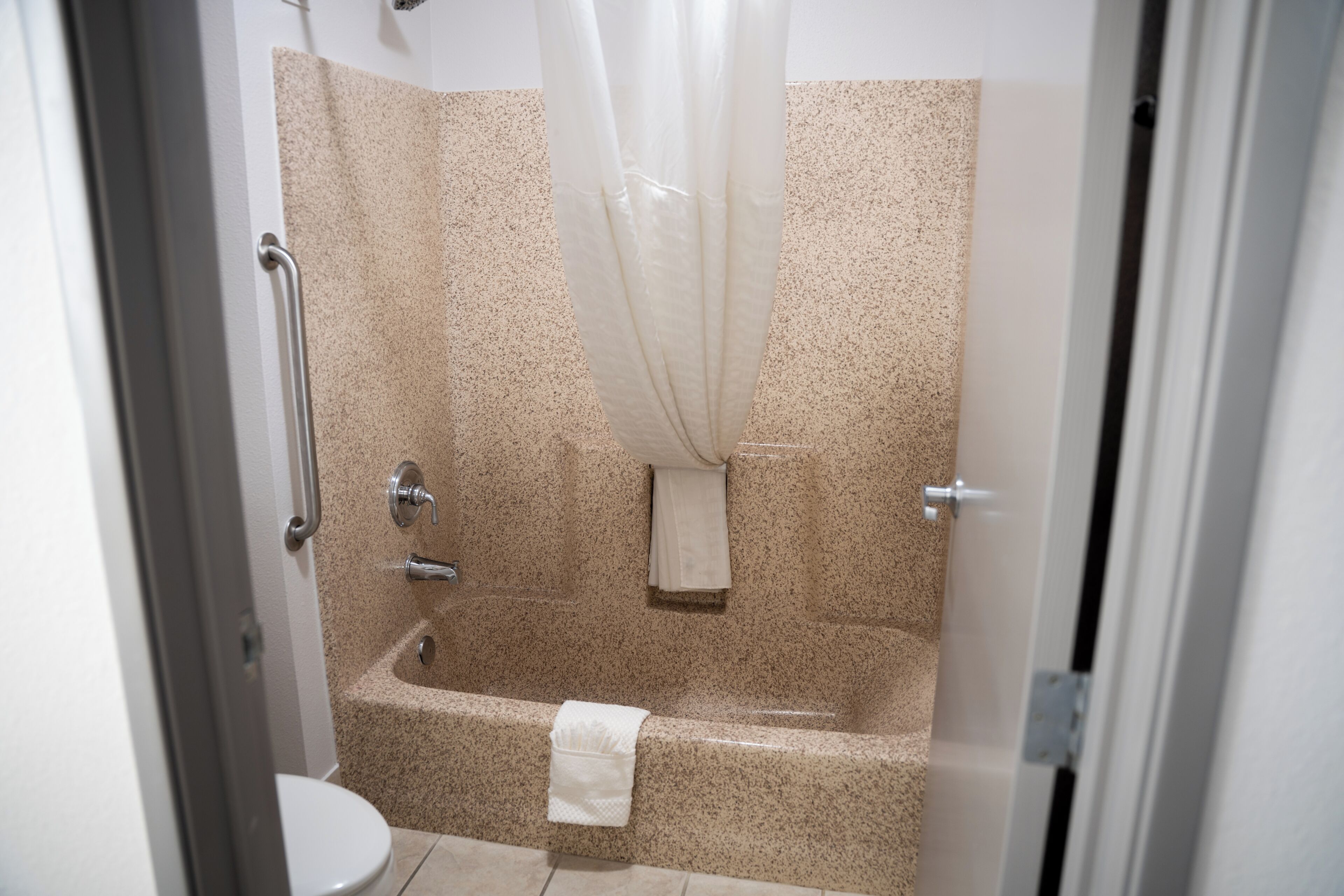 Un baño con bañera, inodoro y cortina de ducha.