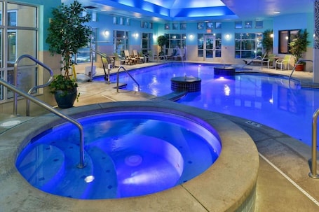 An indoor swimming pool with a hot tub, lounge chairs, and potted plants.. Comfort Suites Airport Tukwila Seattle