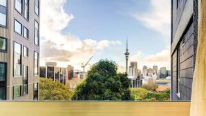 Un rascacielos con vistas a un horizonte urbano, incluyendo una torre destacada.