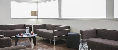 Un salon moderne avec un canapé, une table basse et une lampe.