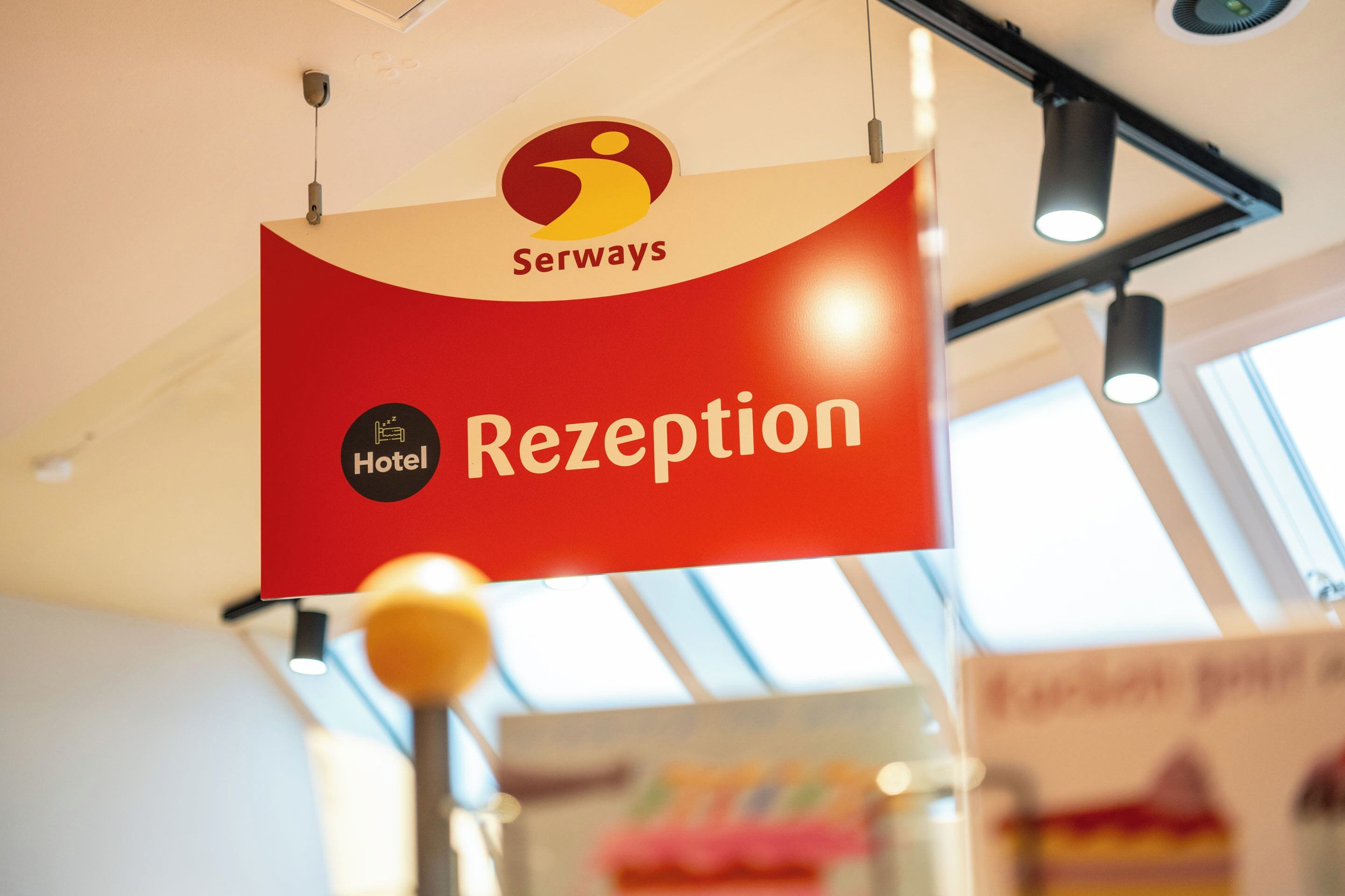 Senyal de recepció d'hotel amb un logotip i la paraula 