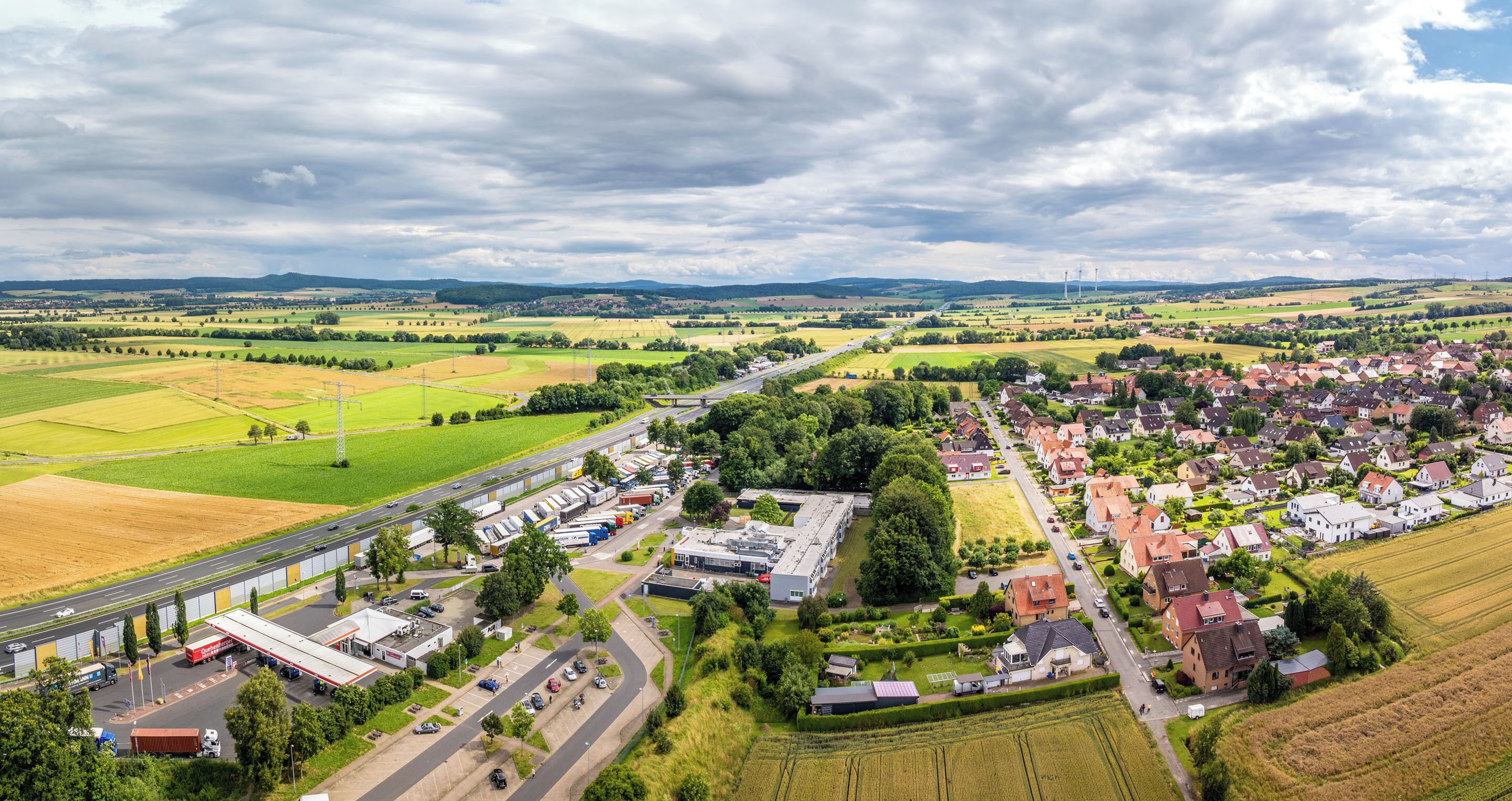 Eine Vogelperspektive einer Stadt mit Hauptstraße, Wohngebieten und Feldern.