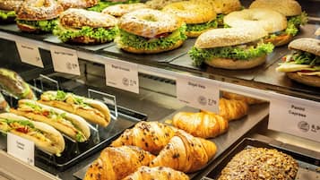 Mostrador de panadería con bagels, croissants y sándwiches.