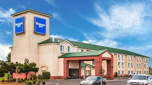 Un hotel Rodeway Inn con un cartello ben visibile, un parcheggio e un tetto verde.