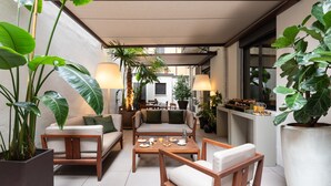 A cozy outdoor seating area with wooden furniture, potted plants, and ambient lighting. - Hotel Cristoforo Colombo – Preferred Hotels & Resorts (Milan)