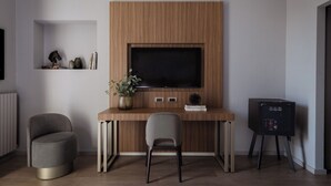 A modern room with a wooden desk, a television, two chairs, and a small side table. - Hotel Cristoforo Colombo – Preferred Hotels & Resorts (Milan)