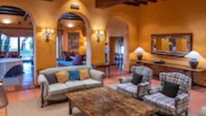 A spacious living area with a wooden coffee table, sofas, and armchairs. - Gran Hotel Rey Don Jaime (Castelldefels)