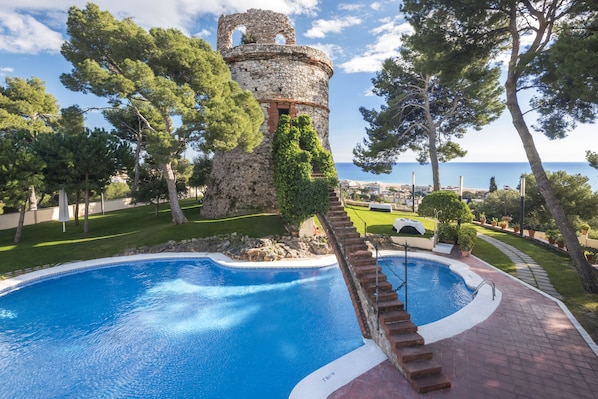 Una piscina al aire libre de temporada, sillones reclinables de piscina