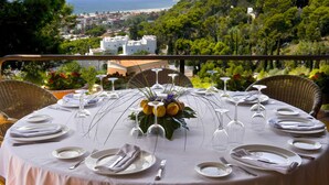 A table set for a meal with a view of the sea and hills. - Gran Hotel Rey Don Jaime (Castelldefels)