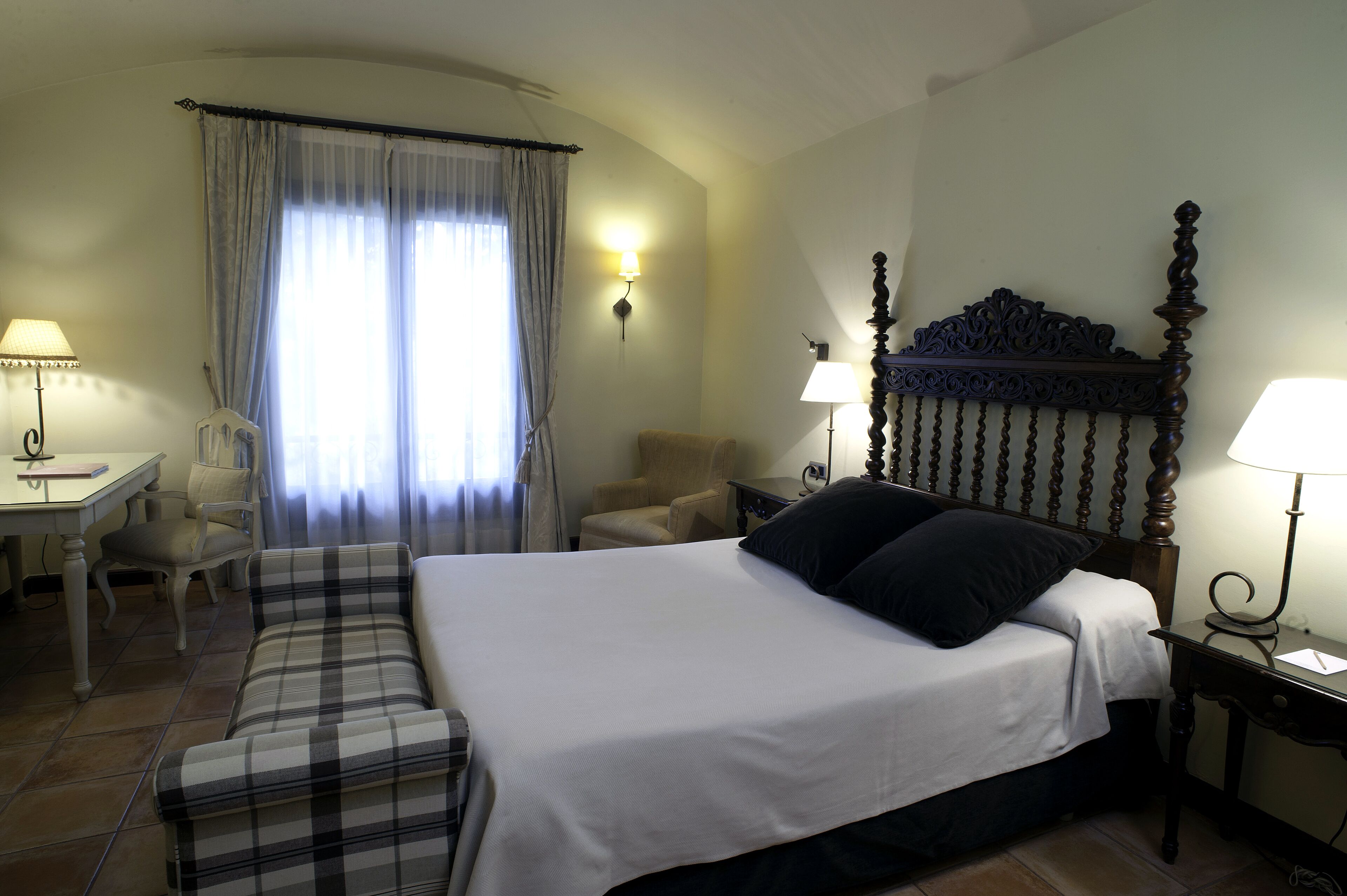 Une chambre d’hôtel avec un lit, un canapé, un bureau et une chaise.