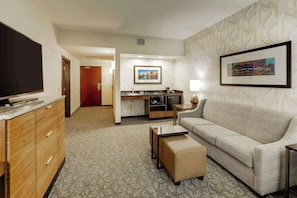 A hotel room with a kitchenette, a sofa, a TV, and a framed picture on the wall. - Drury Plaza Hotel Columbus Downtown (Columbus)