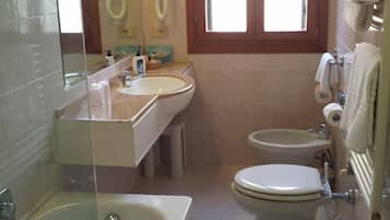 A small bathroom with a sink, a toilet, and a bidet.
